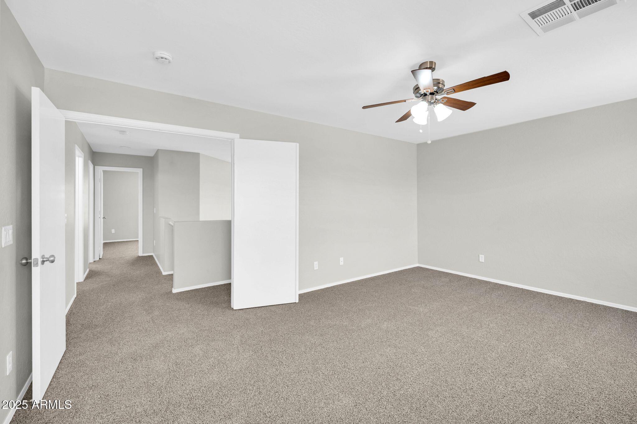 2605 West Darrel Road Phoenix, AZ 85041 - Photo 19 of 33 an empty room with a ceiling fan and a window