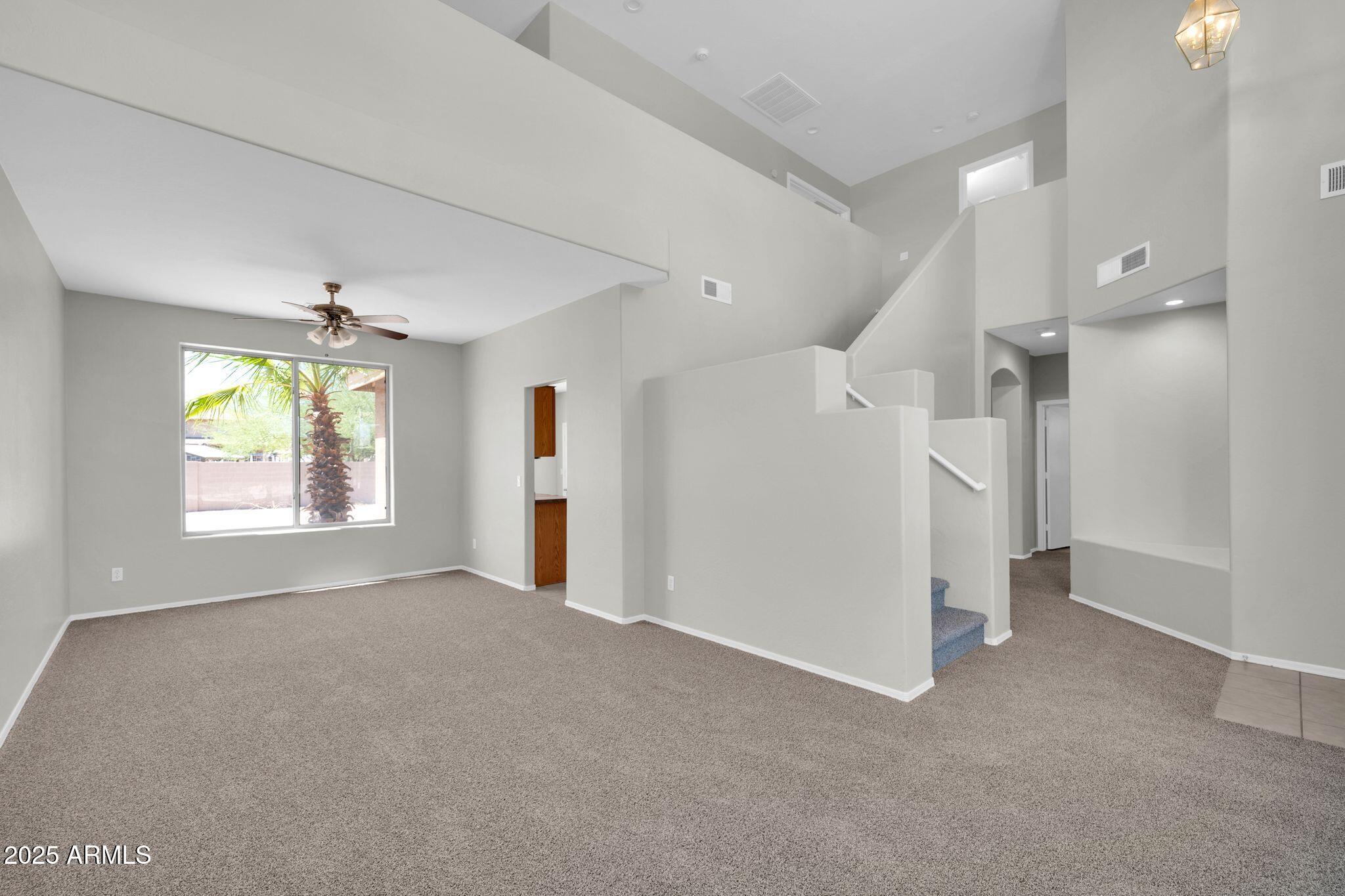 2605 West Darrel Road Phoenix, AZ 85041 - Photo 5 of 33 an empty room with windows and chandelier fan
