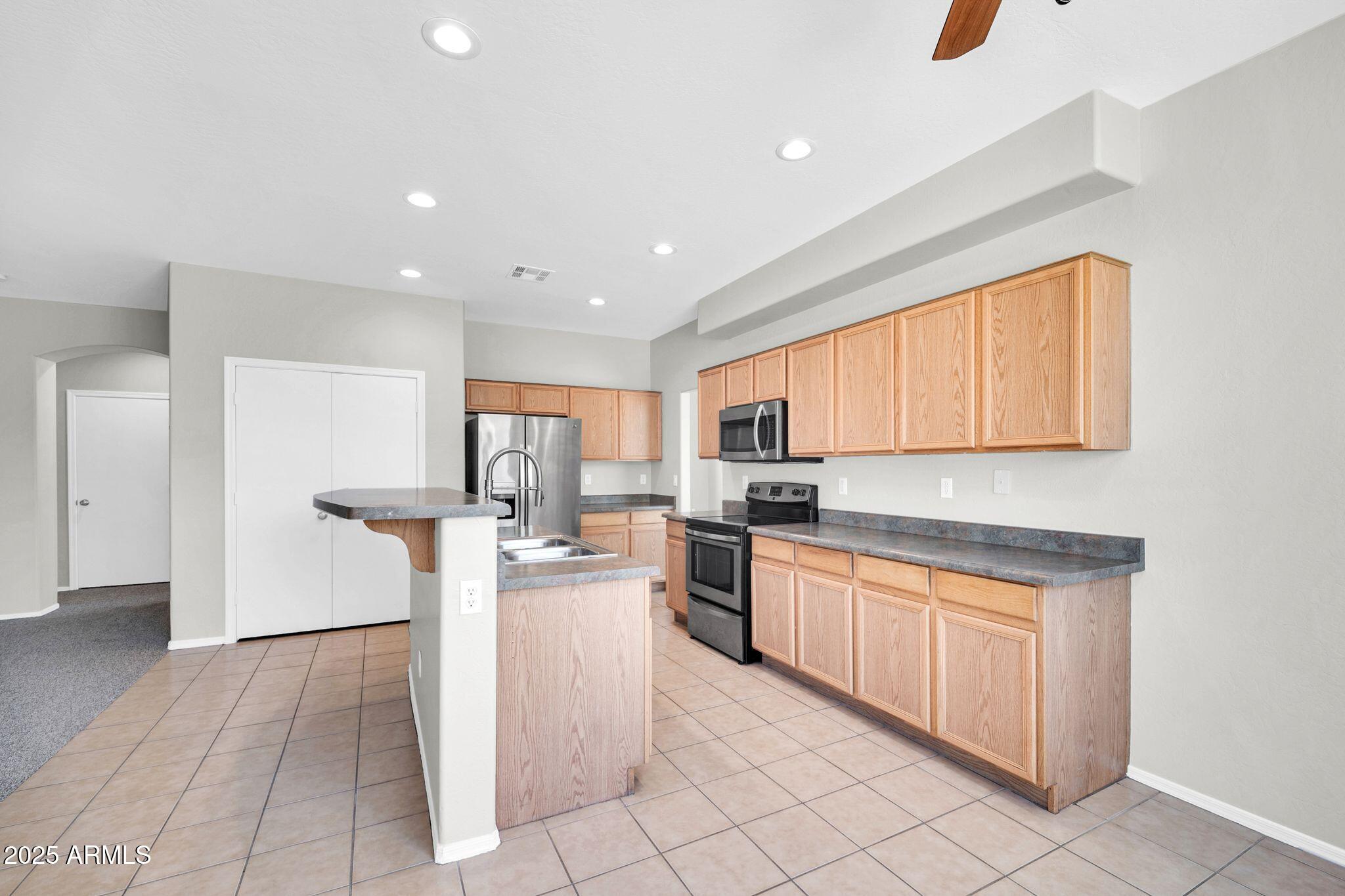 2605 West Darrel Road Phoenix, AZ 85041 - Photo 9 of 33 a kitchen with stainless steel appliances kitchen island granite countertop a sink and cabinets