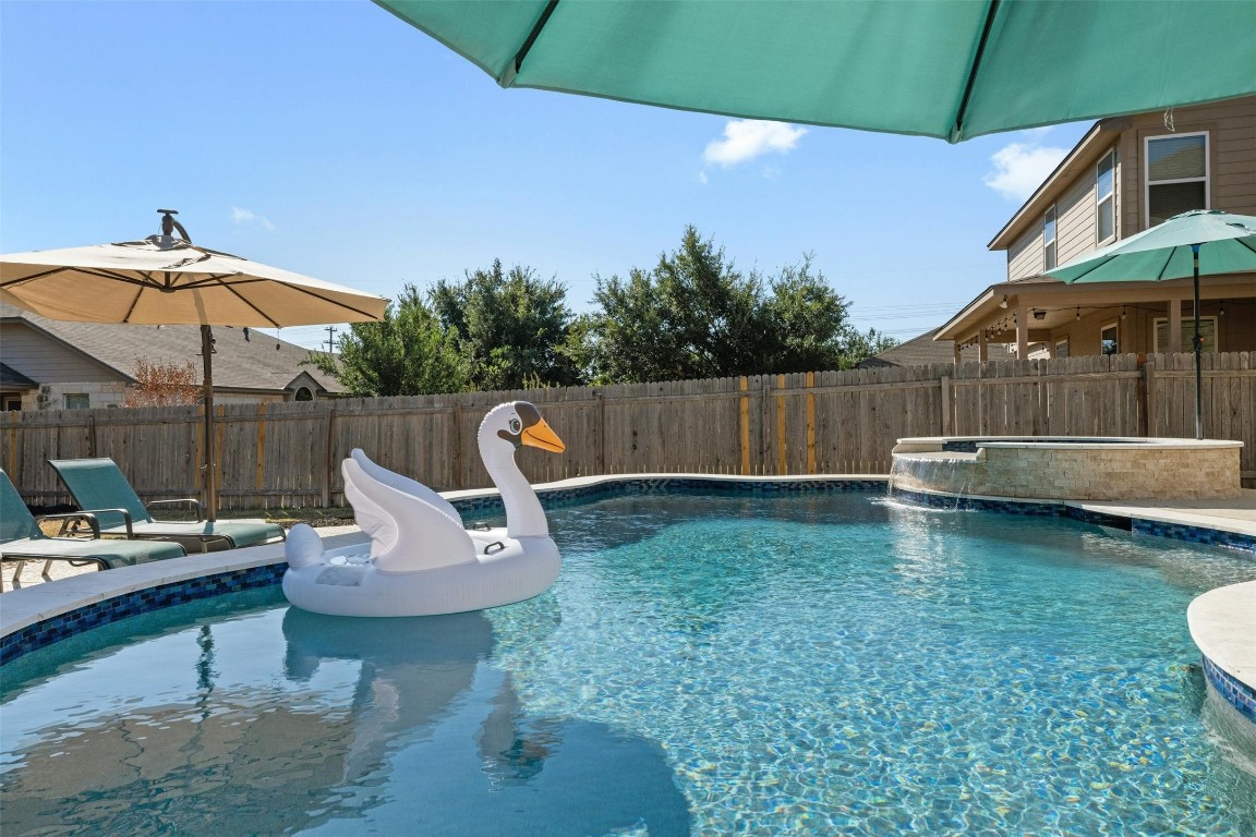 a view of a backyard with table and chairs under an umbrella