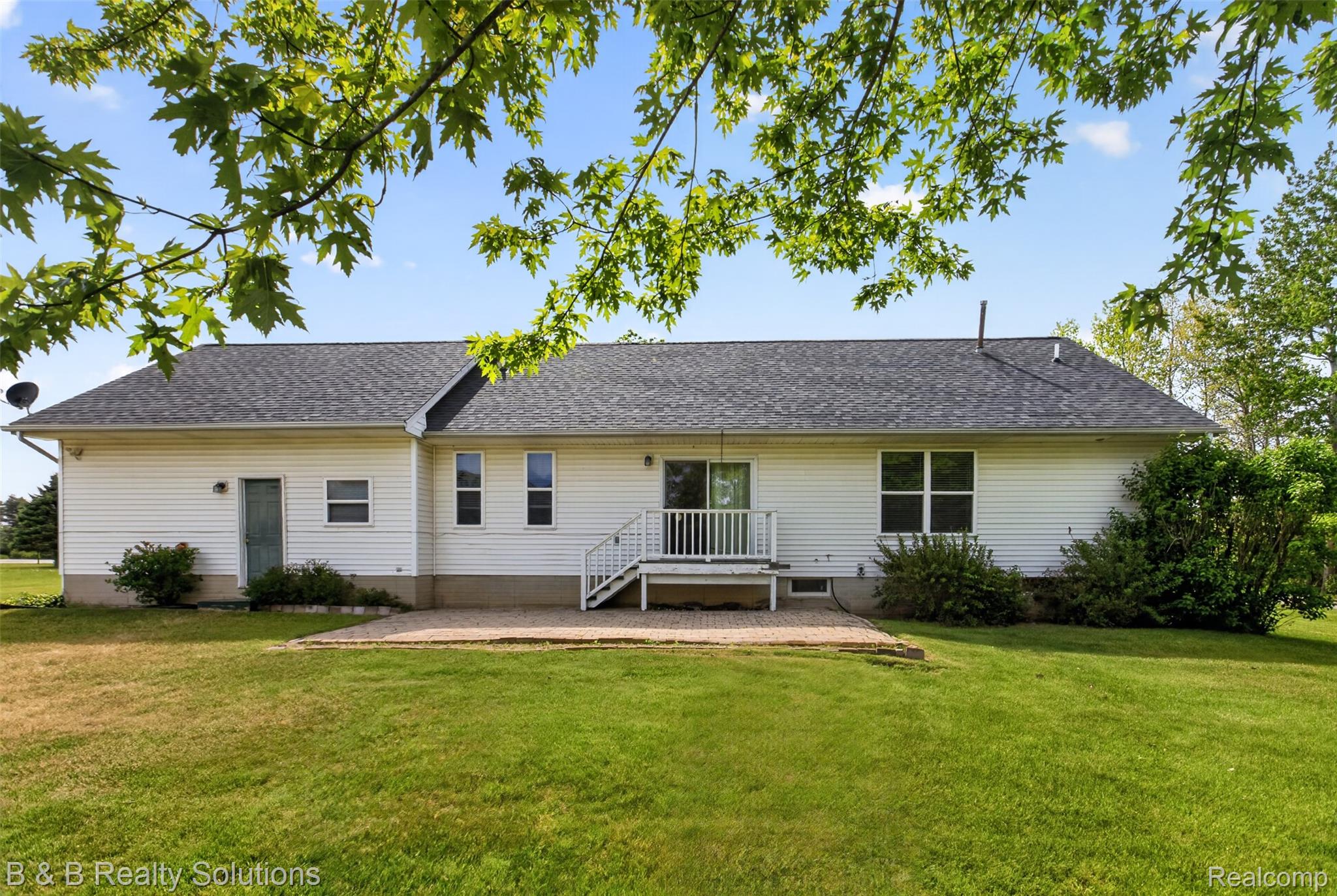 6100 Fish Lake Road North Branch, MI 48461 - Photo 35 of 45 Rear view of property featuring a patio, a shingled roof, and a lawn