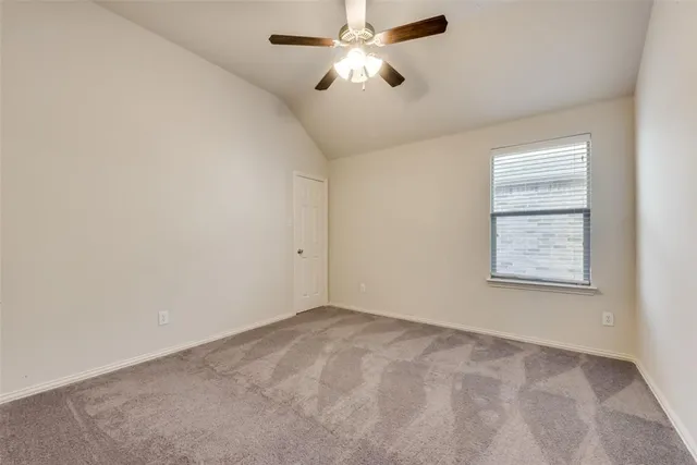 a view of an empty room and chandelier fan