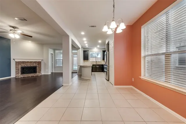 a view of an empty room with a fireplace and a window