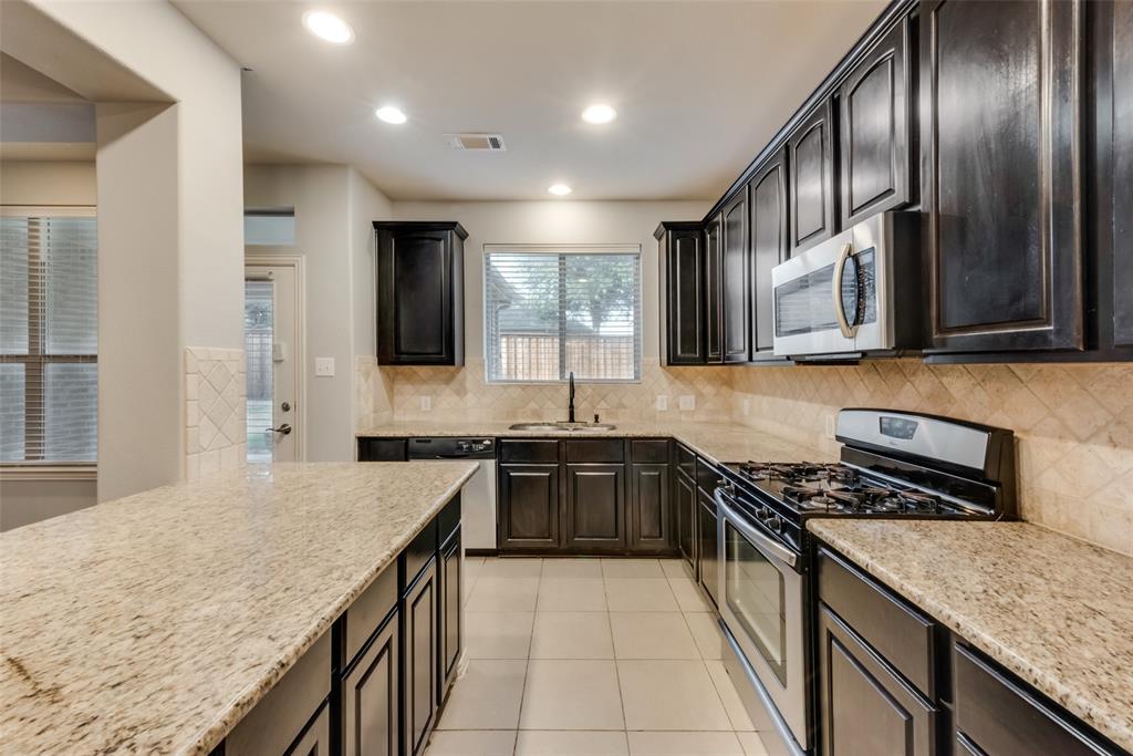 10620 Sexton Drive McKinney, TX 75072 - Photo 6 of 17 a kitchen with stainless steel appliances granite countertop a sink stove and refrigerator