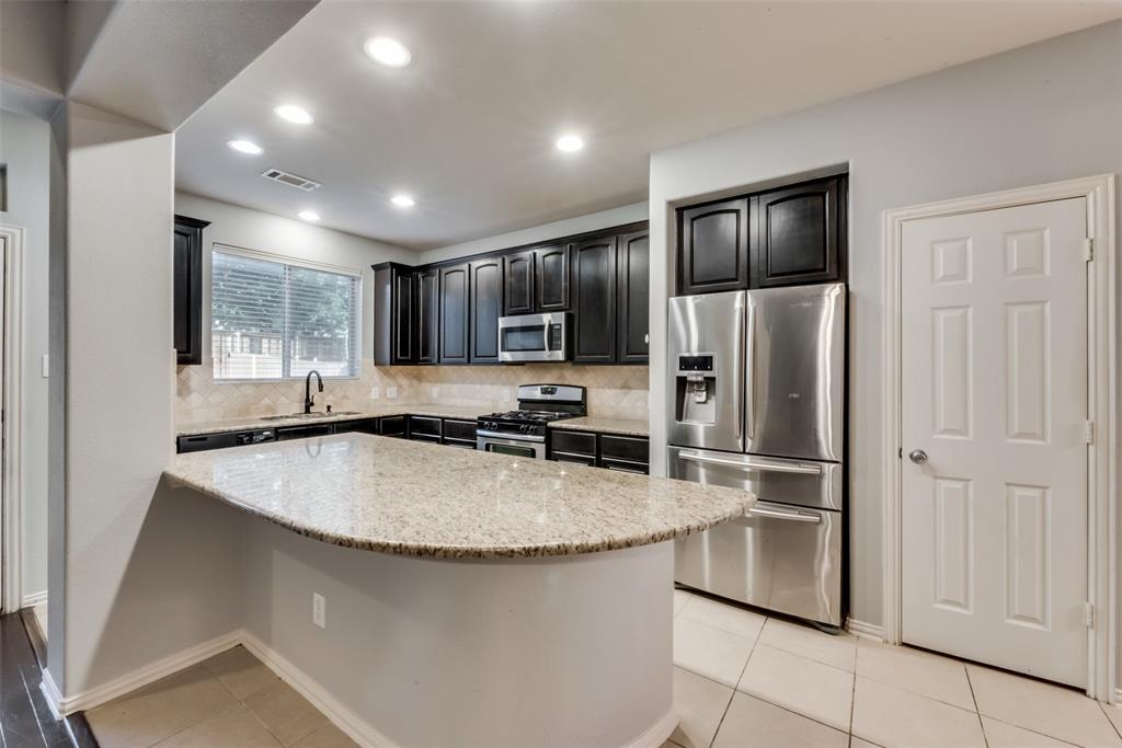 10620 Sexton Drive McKinney, TX 75072 - Photo 7 of 17 a kitchen with stainless steel appliances granite countertop a refrigerator a sink a stove a microwave and island