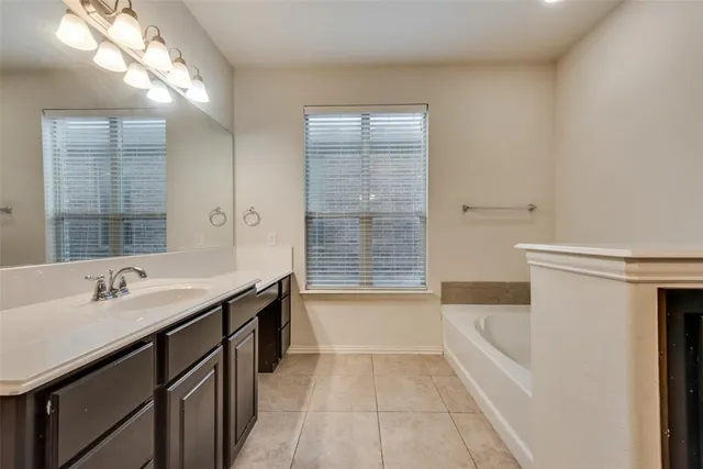 a bathroom with a tub sink and mirror