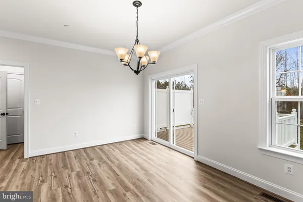 a view of empty room with wooden floor and window