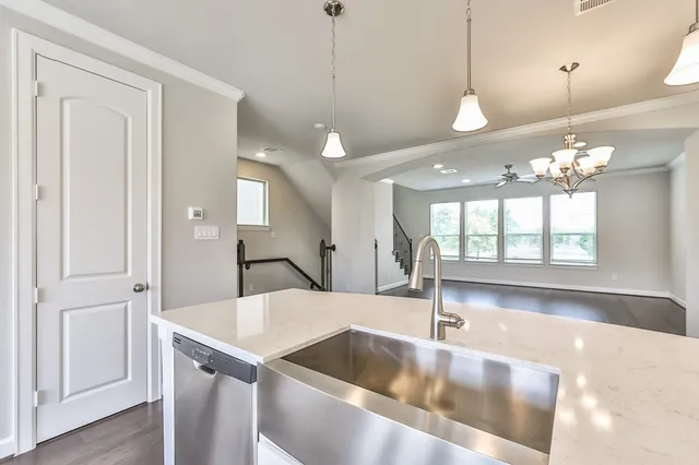 a view of an empty room with a chandelier fan