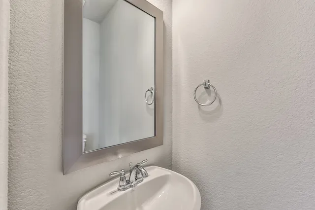 a bathroom with a granite countertop sink and a large mirror