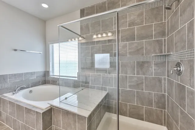 a bathroom with a tub sink and mirror