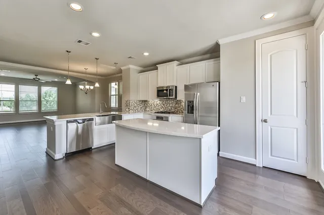 an empty room with a chandelier fan and windows