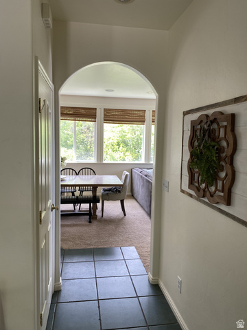 387 North Loafer Canyon Road Payson, UT 84651 - Photo 11 of 94 Arched doorway entry to an interior space featuring a wall of windows, carpeted flooring, and recessed lighting