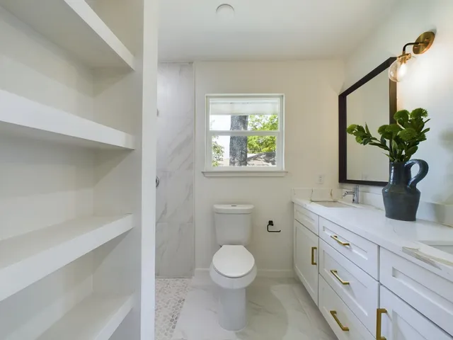 a bathroom with a toilet a sink and mirror