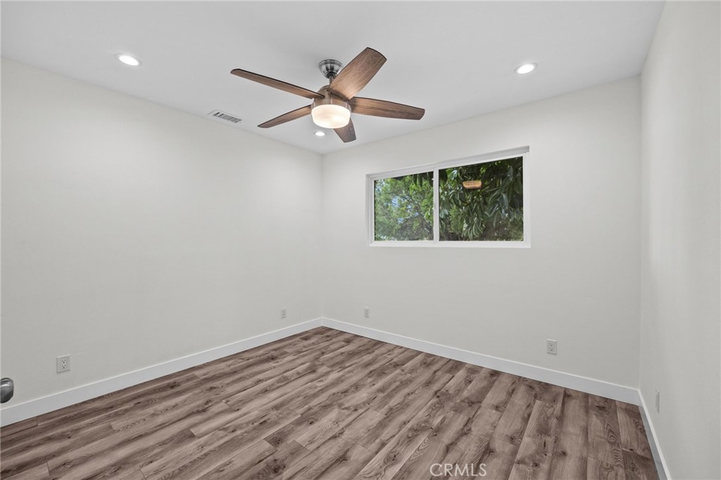 19404 Cheshire Street Rialto, CA 92377 - Photo 16 of 30 an empty room with wooden floor fan and windows