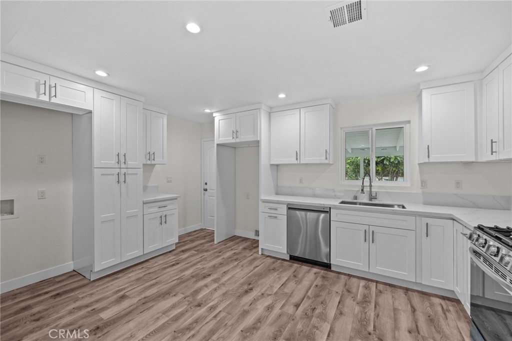 19404 Cheshire Street Rialto, CA 92377 - Photo 8 of 30 a kitchen with white cabinets and white appliances