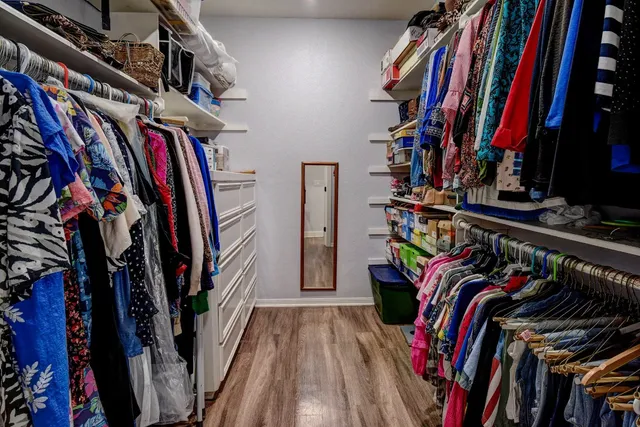 a view of walk in closet with clothes and shoes