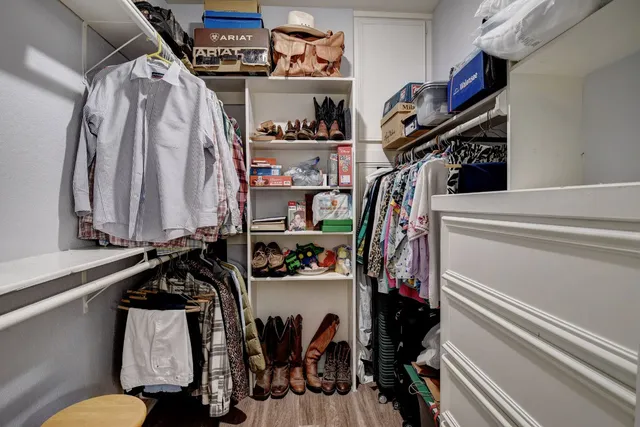 a view of walk in closet with clothes and shoes