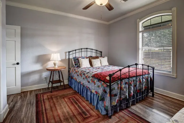 a bedroom with a bed and a lamp on dresser