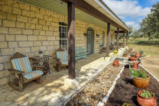 a view of a chair and tables in the patio with a backyard