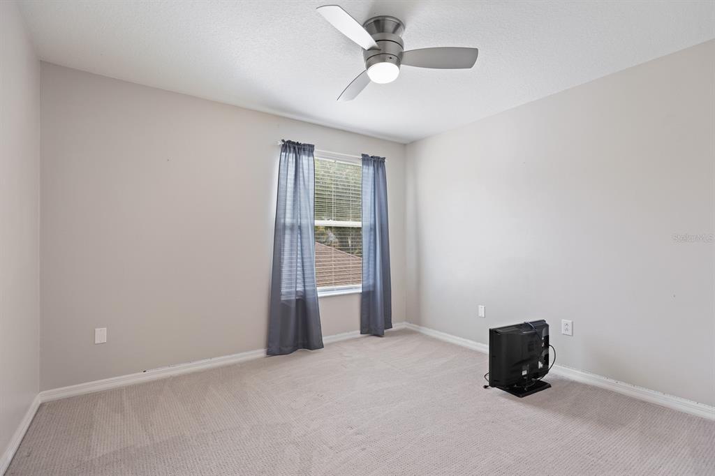 5208 Laurel Pointe Drive Valrico, FL 33596 - Photo 37 of 61 an empty room with a ceiling fan and window