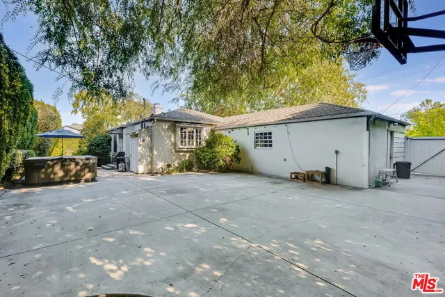 a view of a yard with plants and a bench
