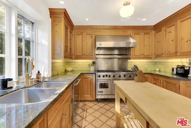 a kitchen with a stove a refrigerator and a sink