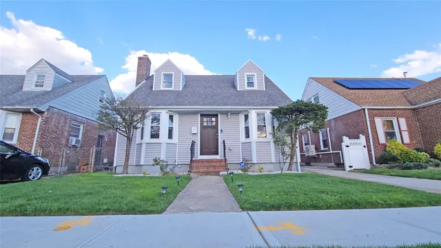a front view of a house with a garden and plants