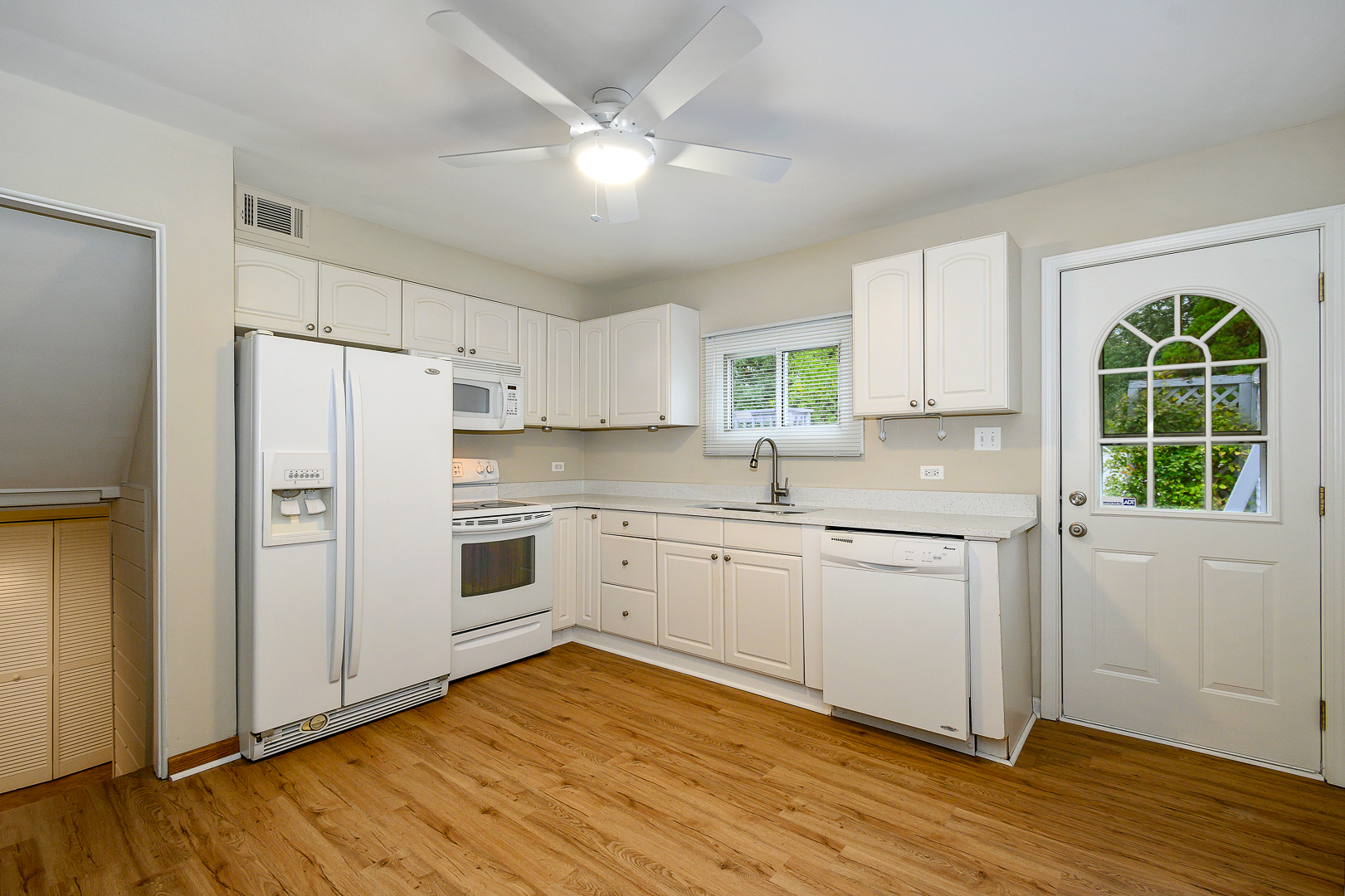 235 West Hickory Road Lombard, IL 60148 - Photo 8 of 23 a kitchen with wooden floors white cabinets and stainless steel appliances