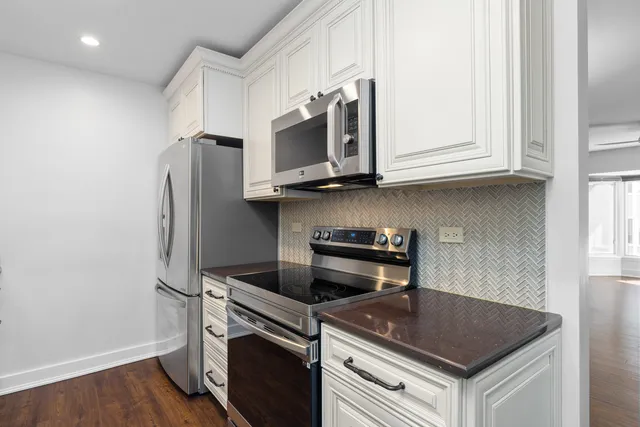 a kitchen with stainless steel appliances granite countertop a stove a refrigerator and a microwave