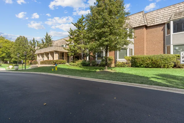 a view of a house with a big yard and large trees