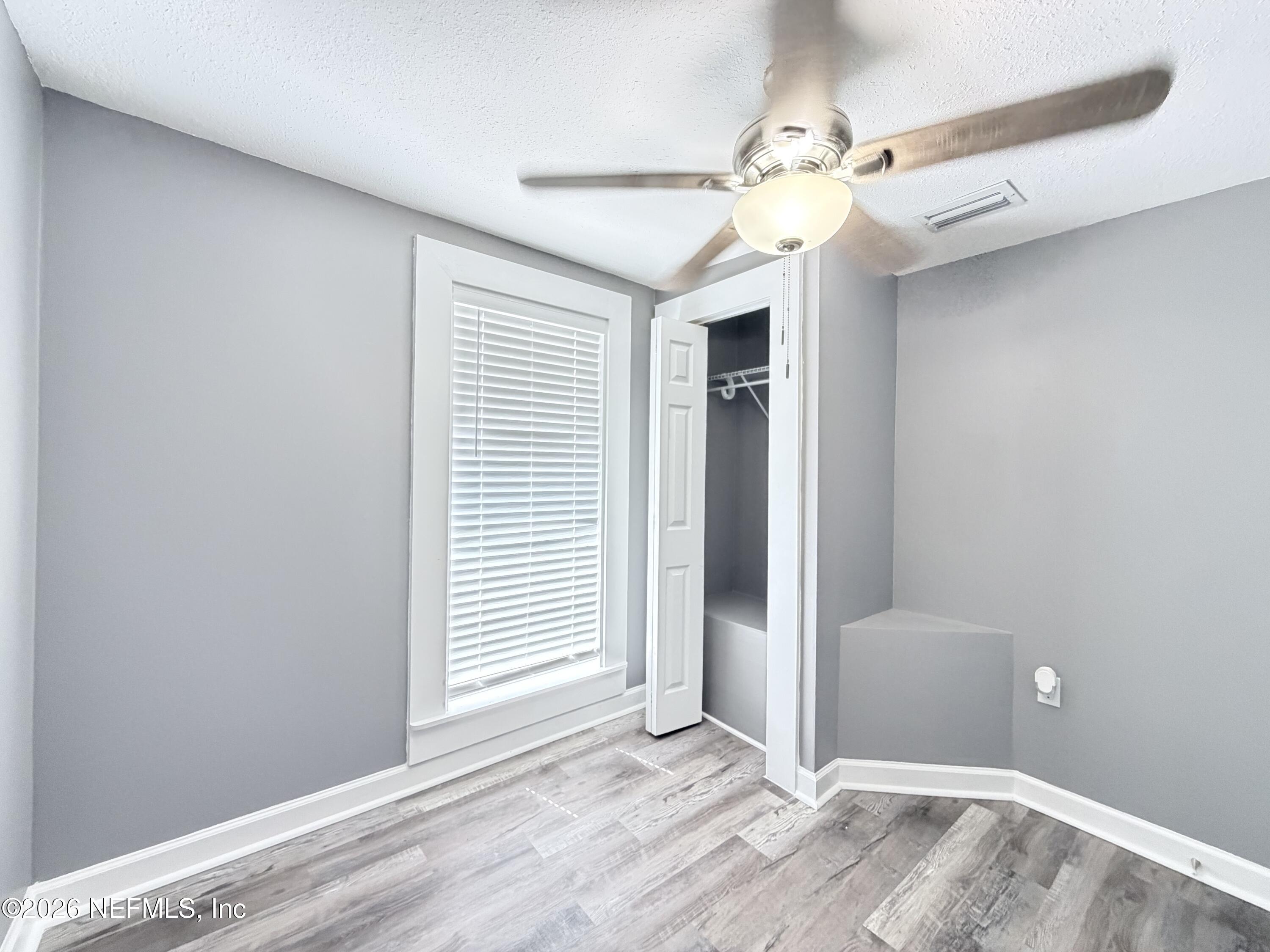 5336 Cruz Road Jacksonville, FL 32207 - Photo 14 of 29 an empty room with a chandelier fan and windows
