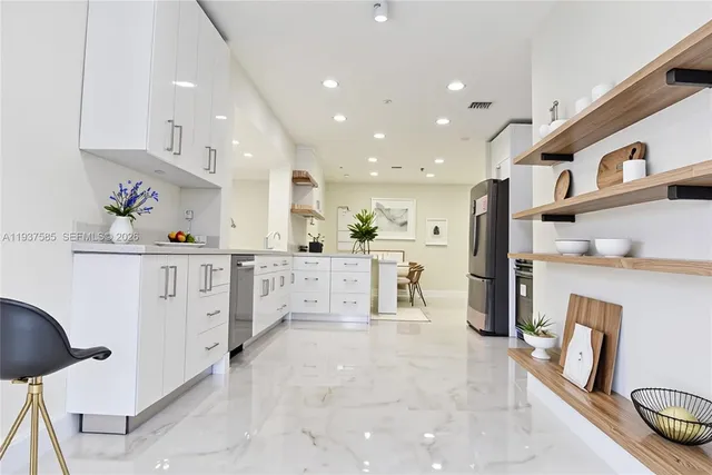 a kitchen with stainless steel appliances kitchen island granite countertop a refrigerator and a stove