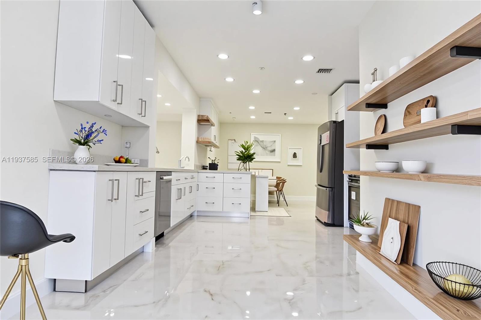 4501 Jefferson Street Hollywood, FL 33021 - Photo 4 of 15 a kitchen with stainless steel appliances kitchen island granite countertop a refrigerator and a stove
