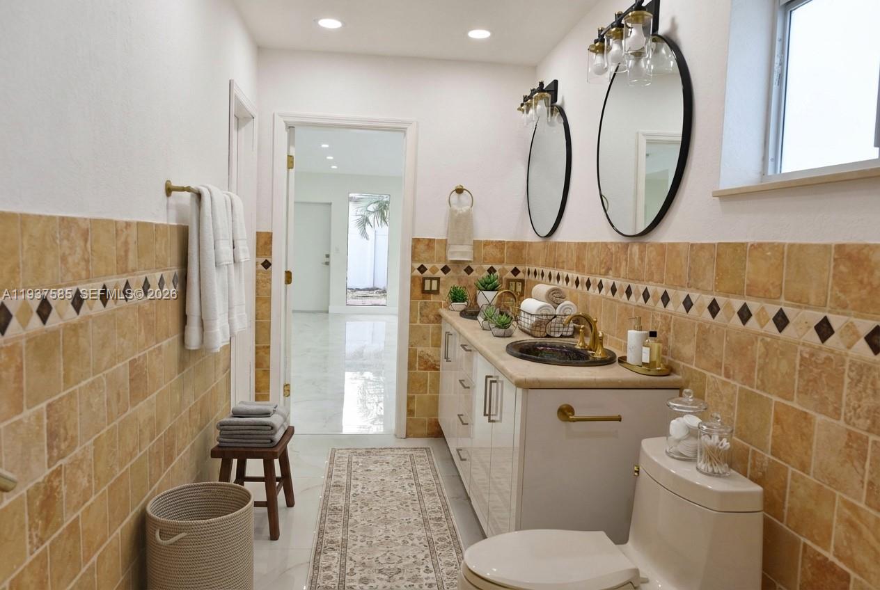 4501 Jefferson Street Hollywood, FL 33021 - Photo 6 of 15 a bathroom with a sink a mirror a toilet and a shower