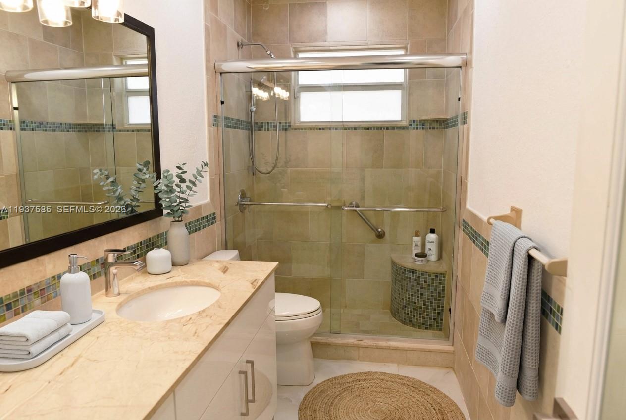 4501 Jefferson Street Hollywood, FL 33021 - Photo 8 of 15 a bathroom with a granite countertop sink toilet and shower
