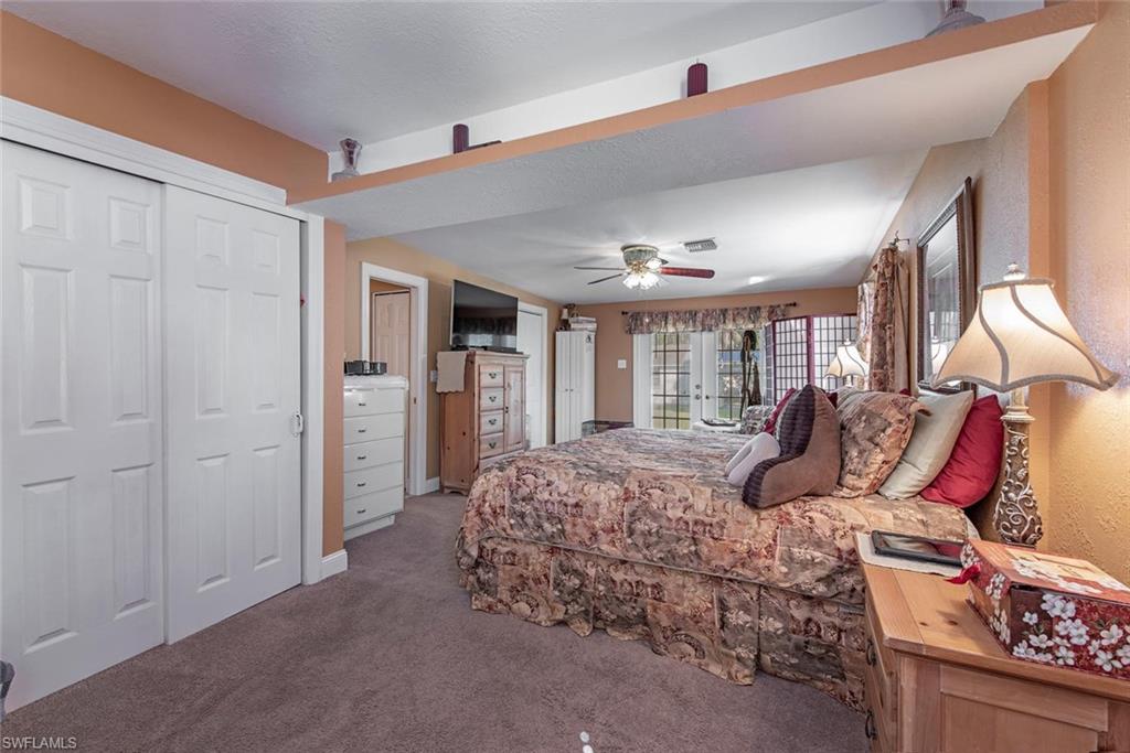 278 Sabal Palm Road Naples, FL 34114 - Photo 6 of 12 a bedroom with a large bed and a chandelier