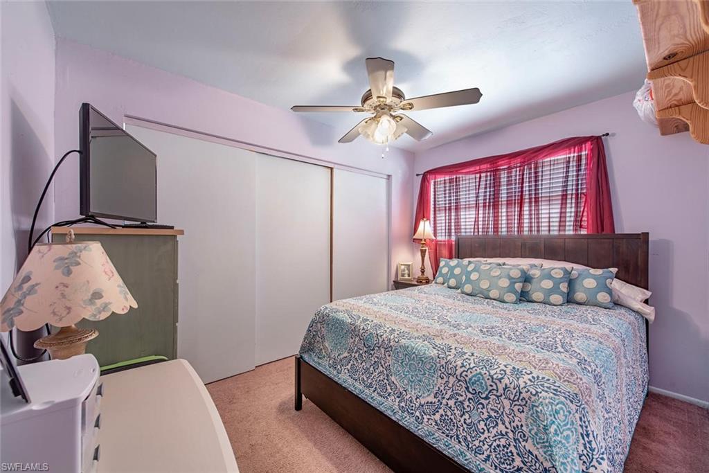 278 Sabal Palm Road Naples, FL 34114 - Photo 7 of 12 a bedroom with a large bed and a chandelier