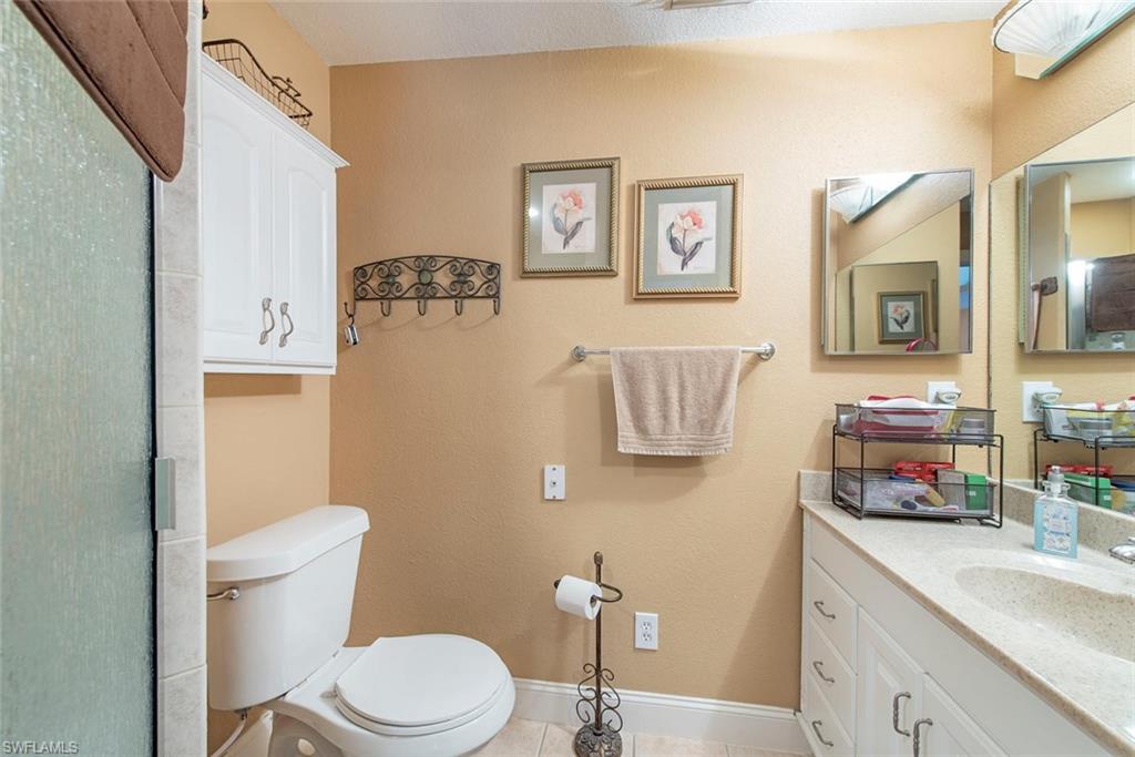 278 Sabal Palm Road Naples, FL 34114 - Photo 8 of 12 a bathroom with a sink a toilet and a mirror