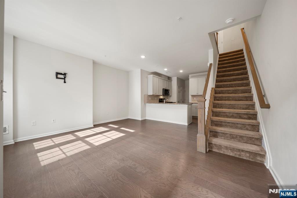 69 Arnold Drive, Unit 5810 Wood-Ridge, NJ 07075 - Photo 11 of 45 a view of an empty room with wooden floor and stairs