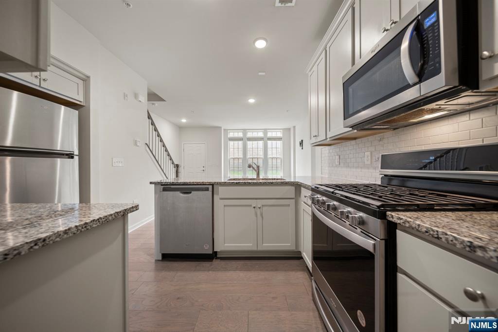 69 Arnold Drive, Unit 5810 Wood-Ridge, NJ 07075 - Photo 13 of 45 a kitchen with a stove and a microwave