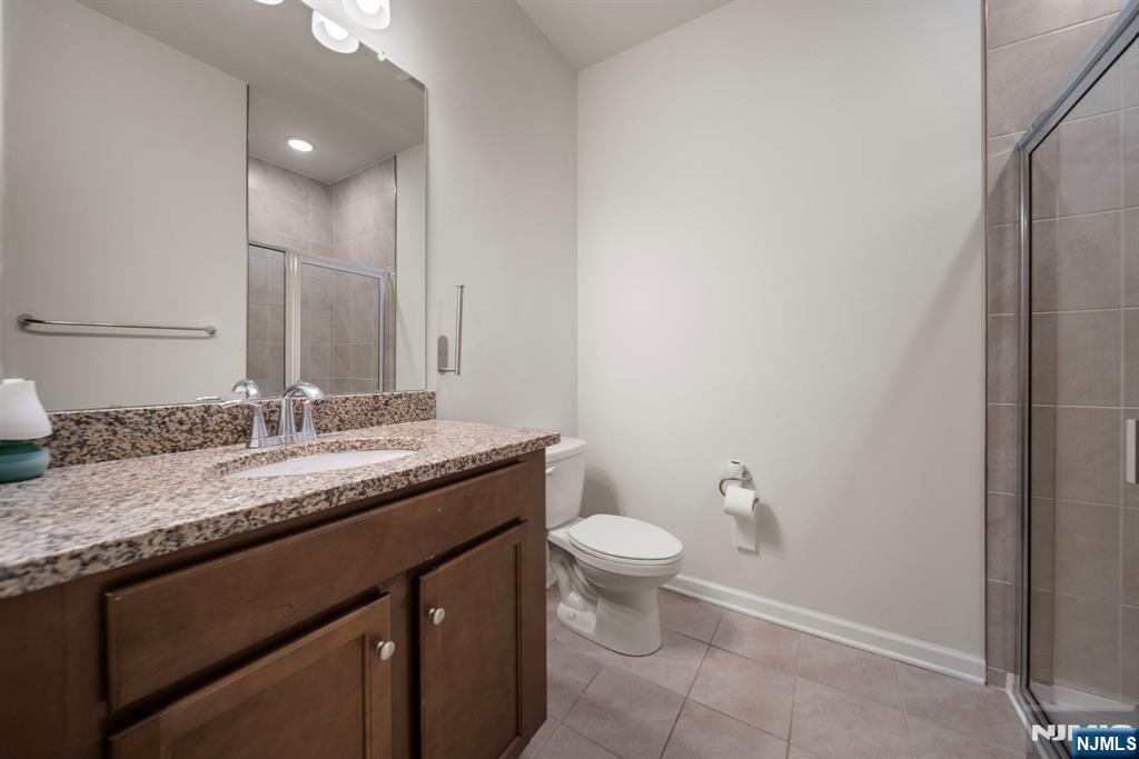 69 Arnold Drive, Unit 5810 Wood-Ridge, NJ 07075 - Photo 17 of 45 a bathroom with a granite countertop sink and a mirror
