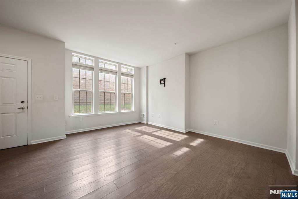 69 Arnold Drive, Unit 5810 Wood-Ridge, NJ 07075 - Photo 8 of 45 a view of an empty room with wooden floor and a window