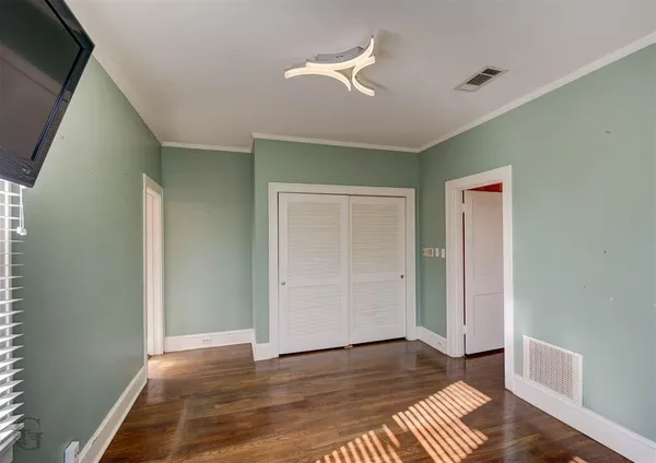 a view of an empty room with wooden floor
