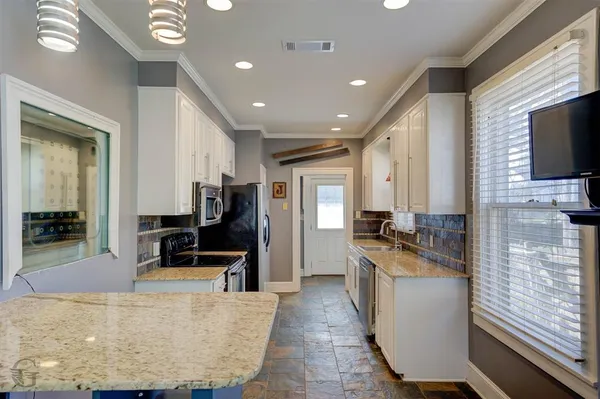 a large kitchen with stainless steel appliances kitchen island granite countertop a large counter top cabinets and stainless steel appliances