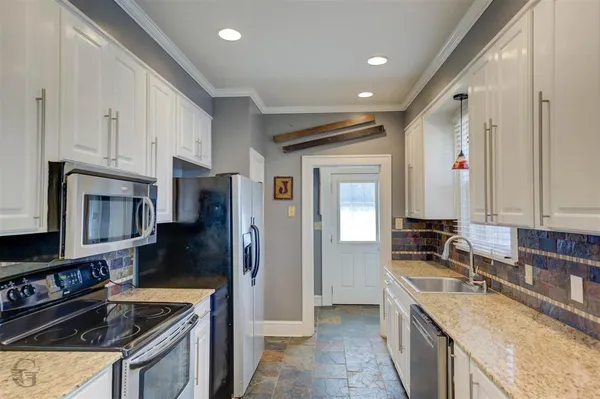 a kitchen with stainless steel appliances granite countertop a sink stove and refrigerator