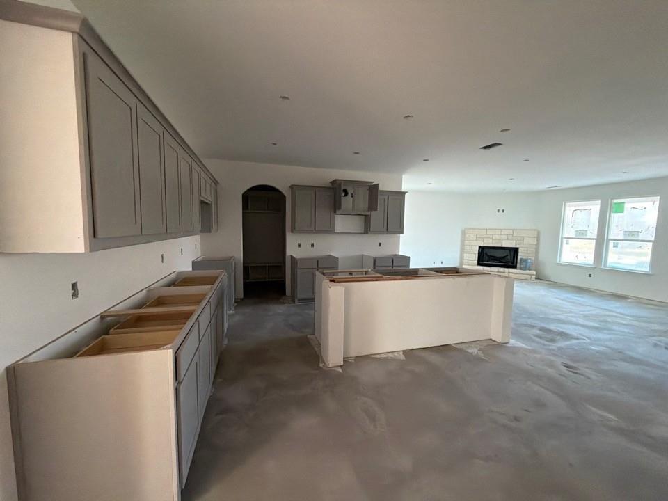 1253 Sabine River Lane Springtown, TX 76082 - Photo 3 of 8 a large kitchen with kitchen island a stove a sink a refrigerator and white cabinets with wooden floor