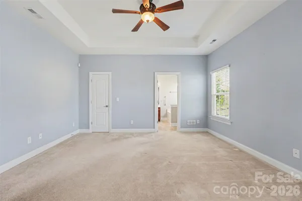 a view of an empty room with window and a ceiling fan