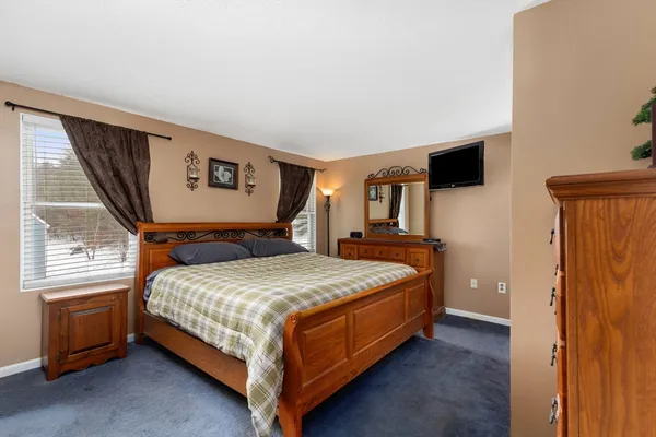 a bedroom with a bed a flat screen tv and dresser
