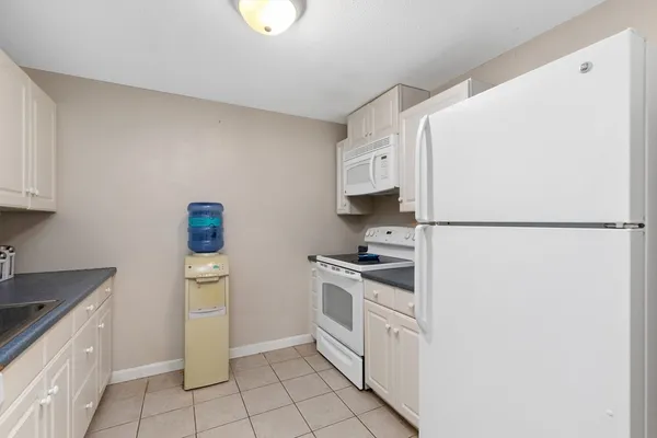 a kitchen with white cabinets and white appliances