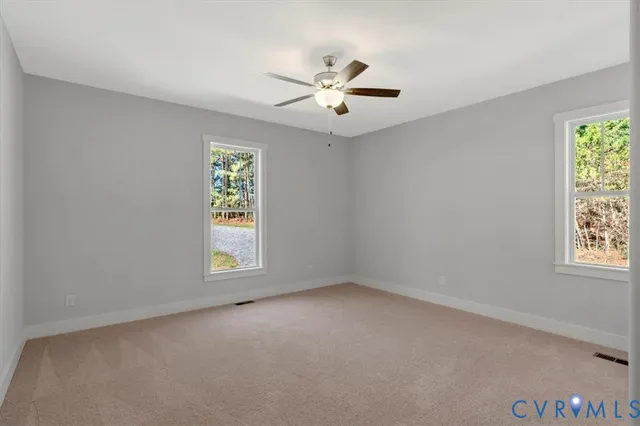 an empty room with windows and fan